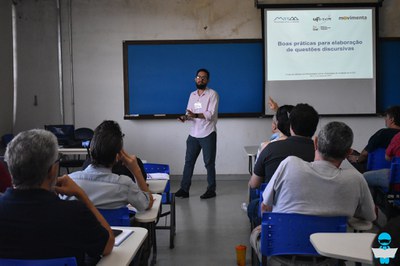 Foto dos professores assistindo uma palestra "Boas práticas para elaboração de questões discursivas", em uma sala de aula.